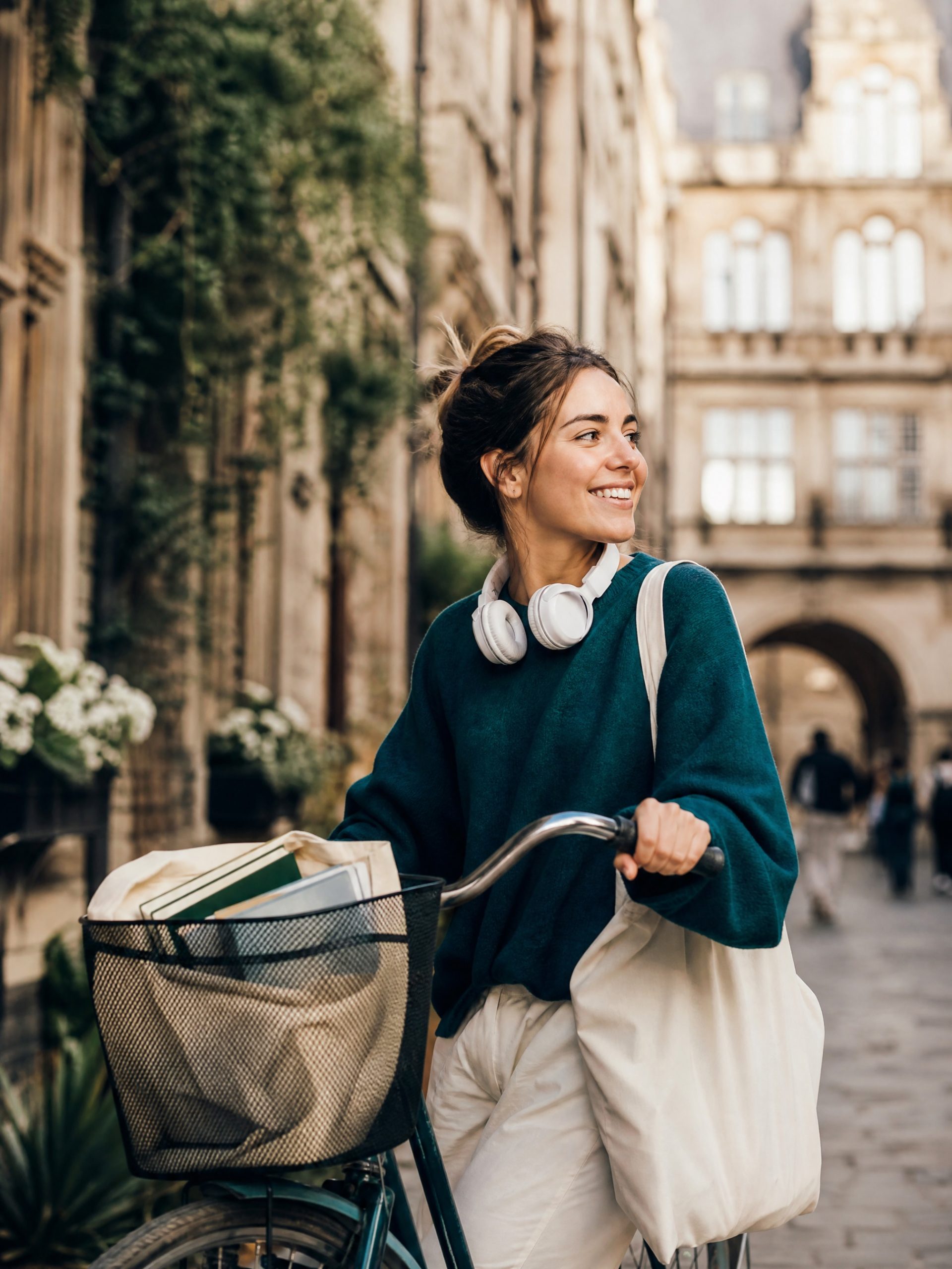 A student crossing a university courtyard with a bag of books